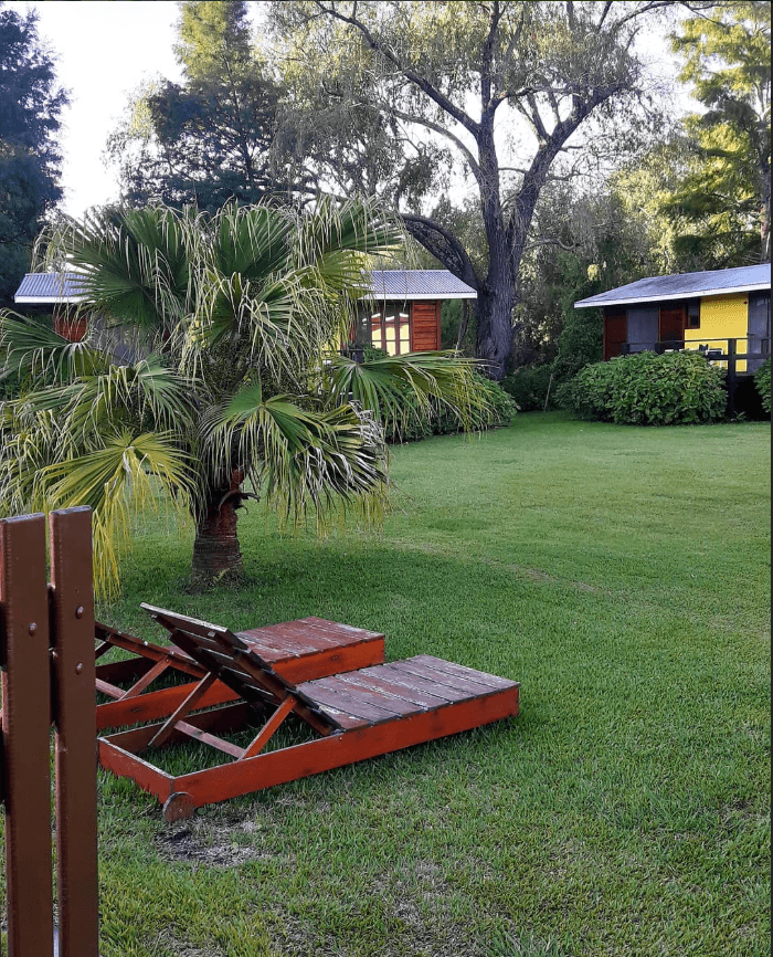 Reposeras de madera al atardecer entre las cabañas